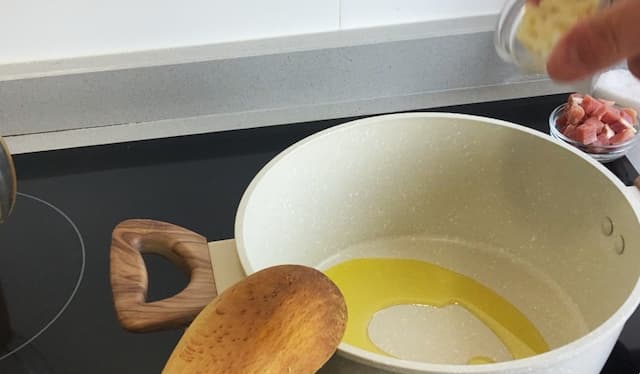 Rehogar las láminas de ajo en una olla con aceite de oliva - Destino Castilla y León
