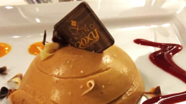 Mouse de chocolate con sirope de fresa y de melocotón, con virutas de chocolate blanco y negro